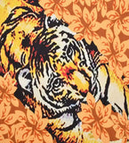 Close-up of a luxury handwoven rug featuring a vibrant tiger print with orange floral patterns.
