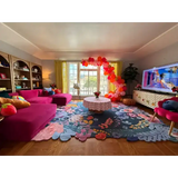 Bright living room with custom floral luxury rug, pink sectional sofa, balloon decoration, and vibrant decor
