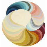 Round luxury handwoven rug with swirling gradient segments in blues, pinks, yellows, and browns
