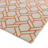 Luxury beige rug with an intricate orange geometric lattice pattern, modern handwoven design