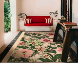 Luxury floral patterned rug with green and pink tones in stylish living room featuring red cushioned sofa and wooden table