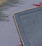 Close-up of modern abstract wave rug with gray and red patterns, showing woven edge detail
