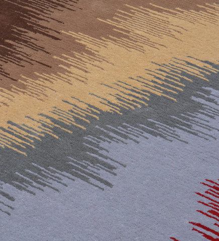 Luxury wool rug featuring bold abstract pattern in warm and cool tones