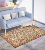 Warm botanical patterned rug with beige and green leaves under light blue sofa in modern living room