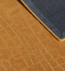 Modern hand-tufted rug in golden tones with embossed detailing