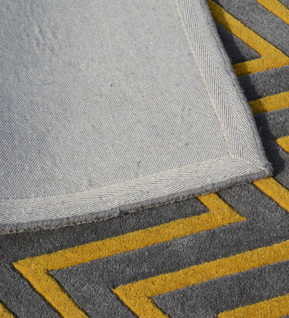 Modern living room rug with gray and mustard yellow accents.