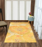 Yellow floral patterned modern rug on wooden floor in bright room with chair and patterned stool