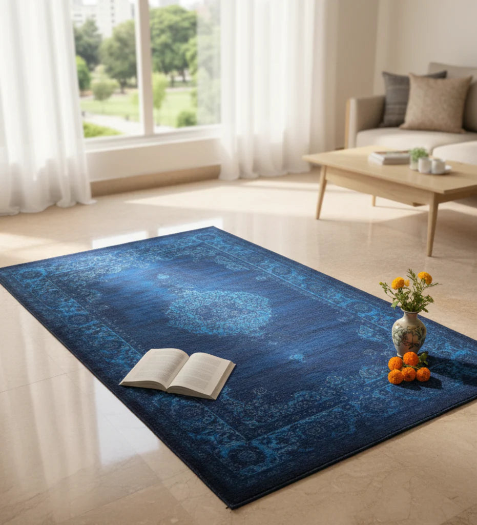 Blue patterned rug in a living room with a book and vase on top