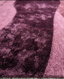 Close-up of a textured purple rug with a checkered pattern on a light wooden floor.