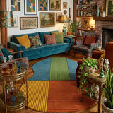 Colorful living room with a blue sofa, patterned rug, and various decor items.