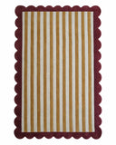 Striped rug with red border featuring vertical gold, white, and gold stripes on a white background
