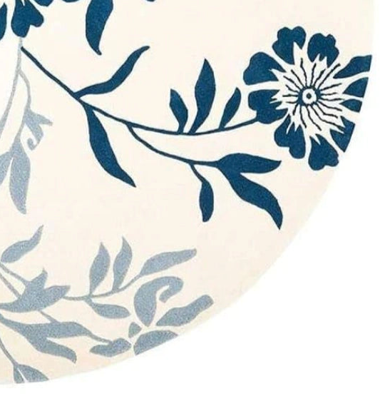 Round area rug featuring a floral vine pattern in navy blue indigo and light blue-gray on an off-white background.