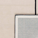 Close-up of handwoven beige New Zealand wool rug with black border detail by Mannat Rugs