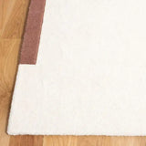 Close-up of luxury handwoven New Zealand wool rug with white and brown geometric corner on wooden floor