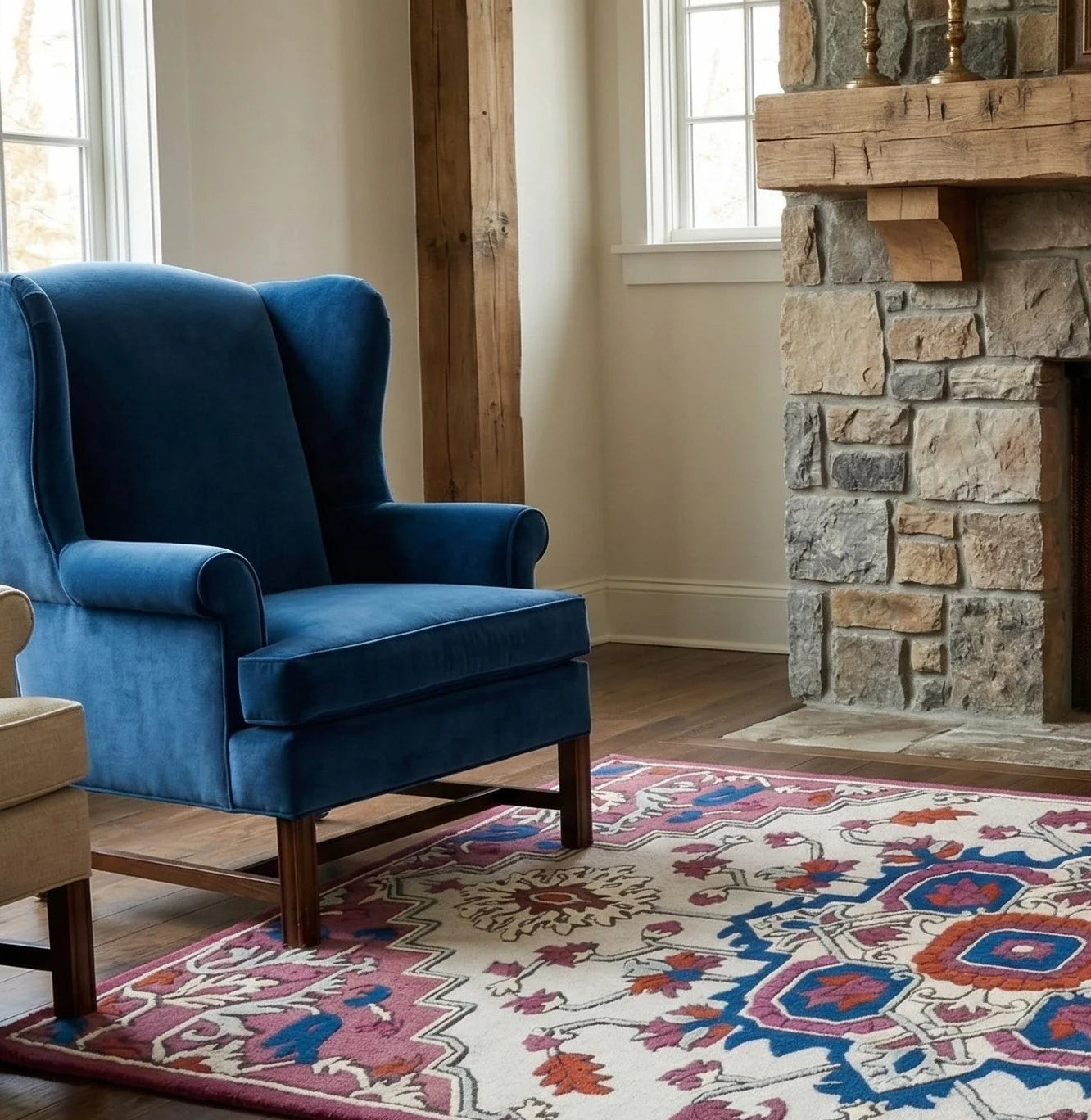 Living room with blue armchair, stone fireplace, and patterned rug.