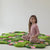 Decorative hand-tufted green wool rug showcasing organic shapes and colorful meadow flowers