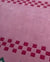 Aesthetic pink scalloped edge rug with red checkerboard border.
