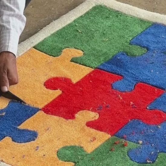 Colorful hand tufted puzzle piece rug finishing process with the artisan