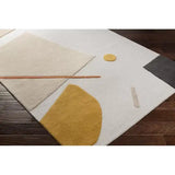 Handwoven luxury wool rug with abstract geometric shapes in beige, mustard, and black on hardwood floor