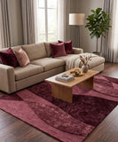 Living room with beige sectional sofa, red and pink pillows, and a wooden coffee table on a burgundy rug.