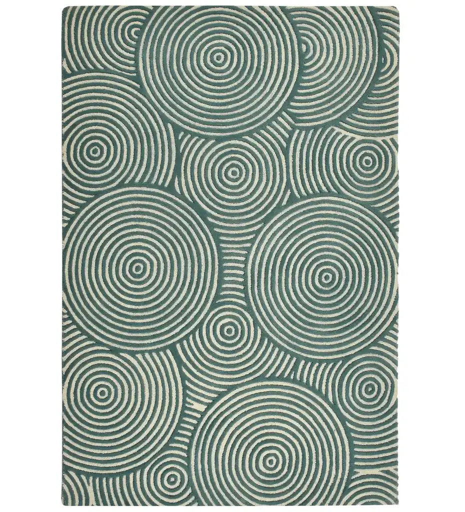 A rectangular area rug featuring a repeating pattern of concentric circles in dark teal green and off-white, shown flat against a white background.
