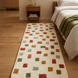 Colorful patterned rug on a wooden floor in a bedroom setting.