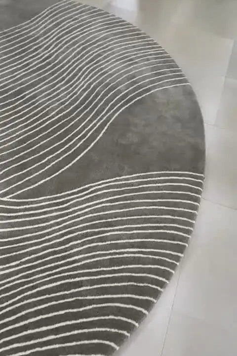 Gray area rug with white lines on a white floor.